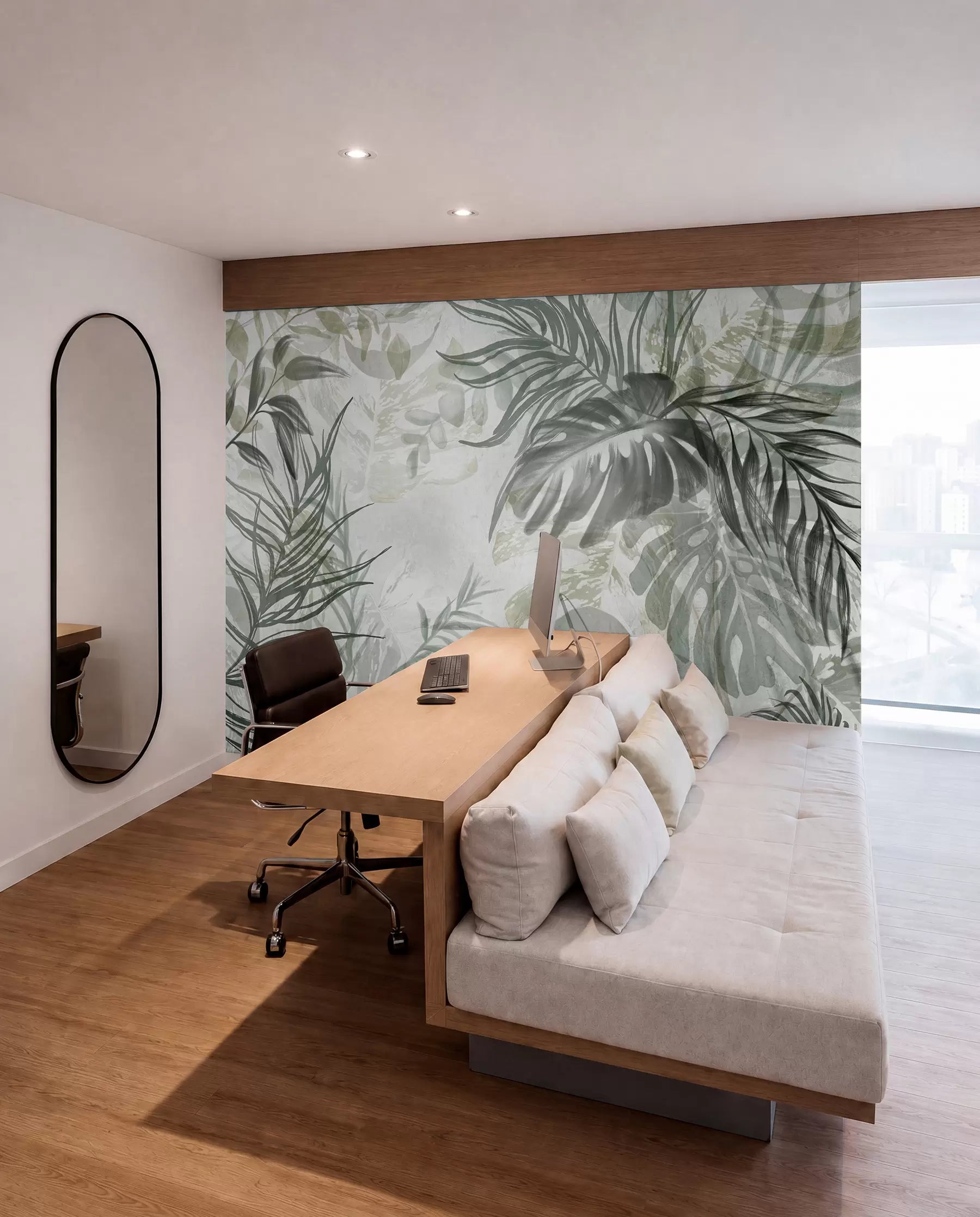 Green and grey tropical leaf mural in a room with a sofa and wooden desk