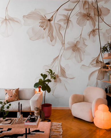 Translucent beige flowers hanging from branches wall mural in a living room with a cream boucle armchair
