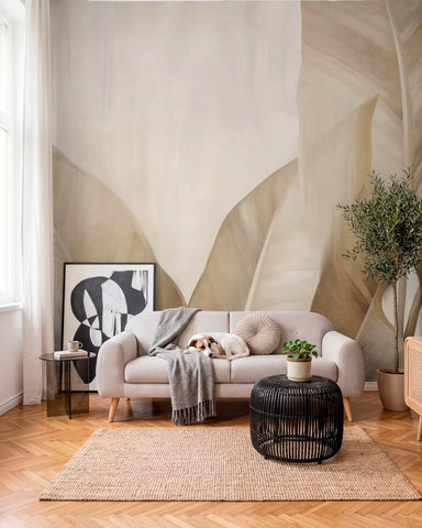Minimalist banana leaf mural in a living room with a grey sofa