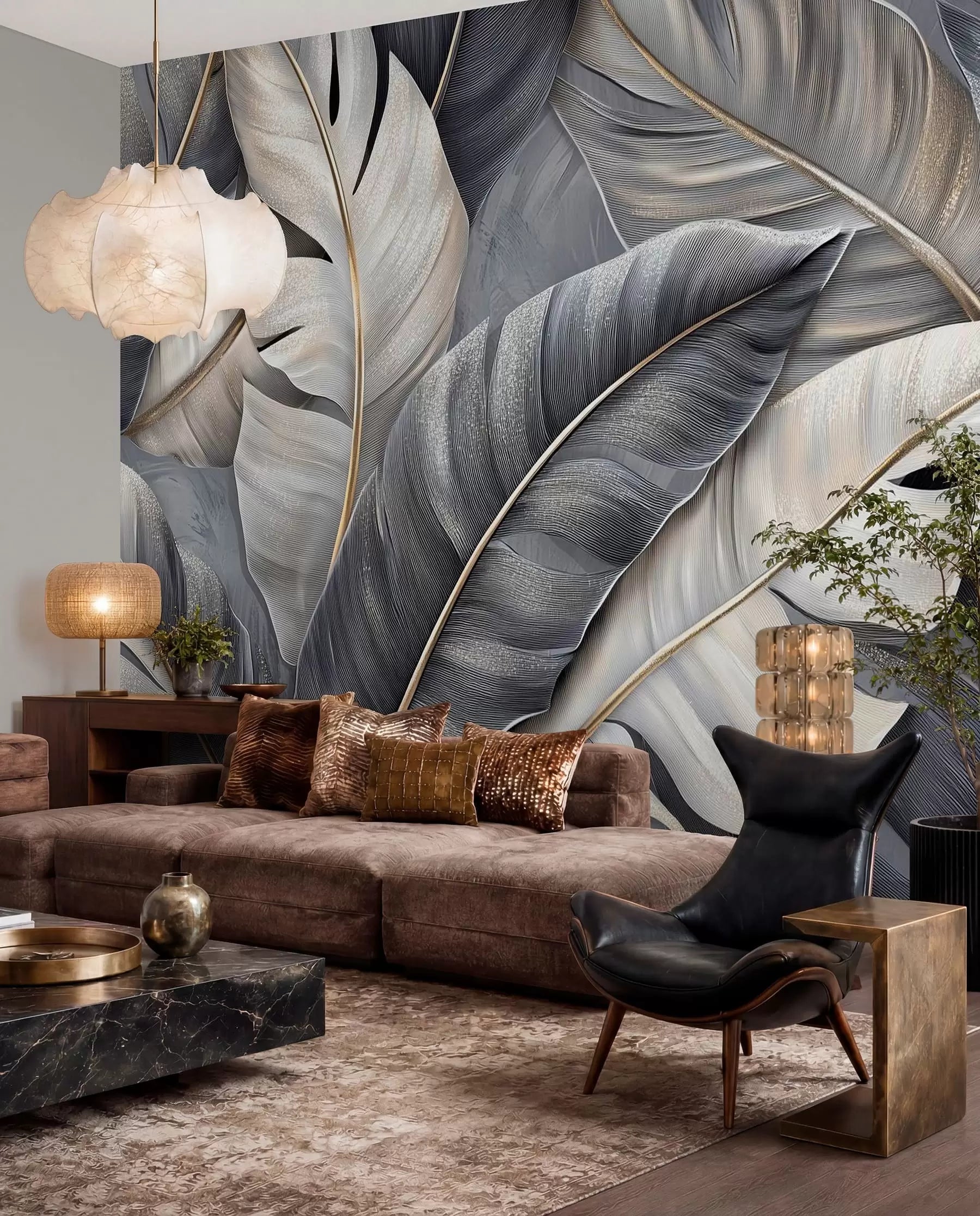 Large charcoal, grey and cream tropical leaves wall mural behind a brown sofa and black lounge chair