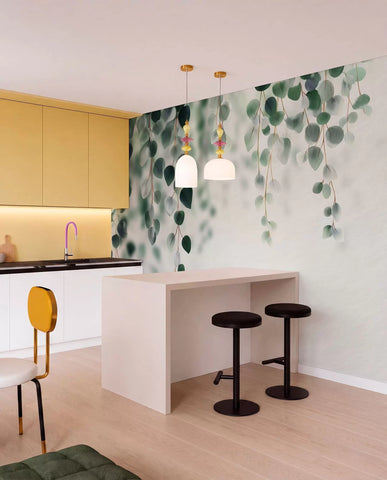 Trailing eucalyptus mural in a kitchen with yellow cabinets and black bar stools