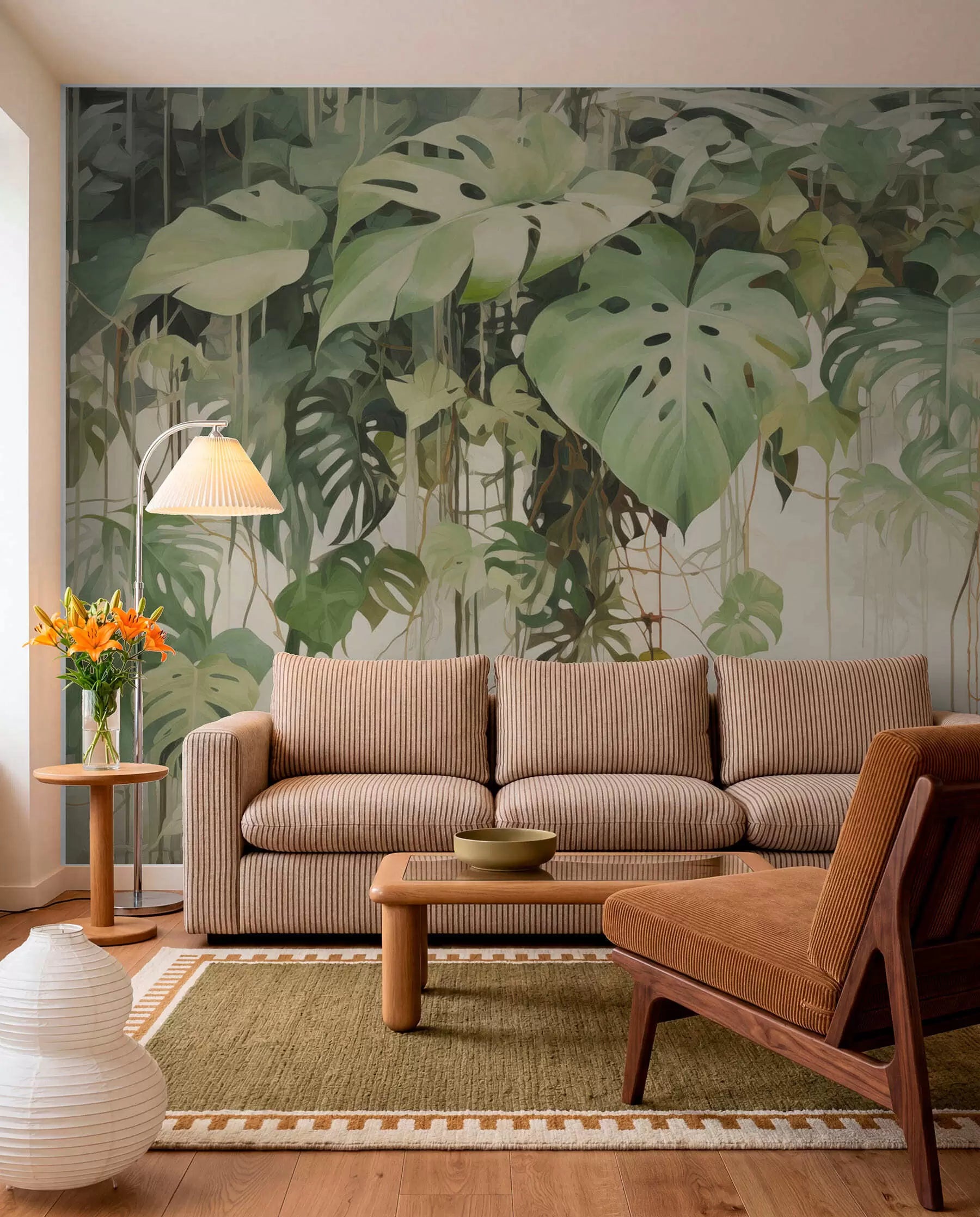Green tropical leaf mural behind a tan leather sofa in a living room