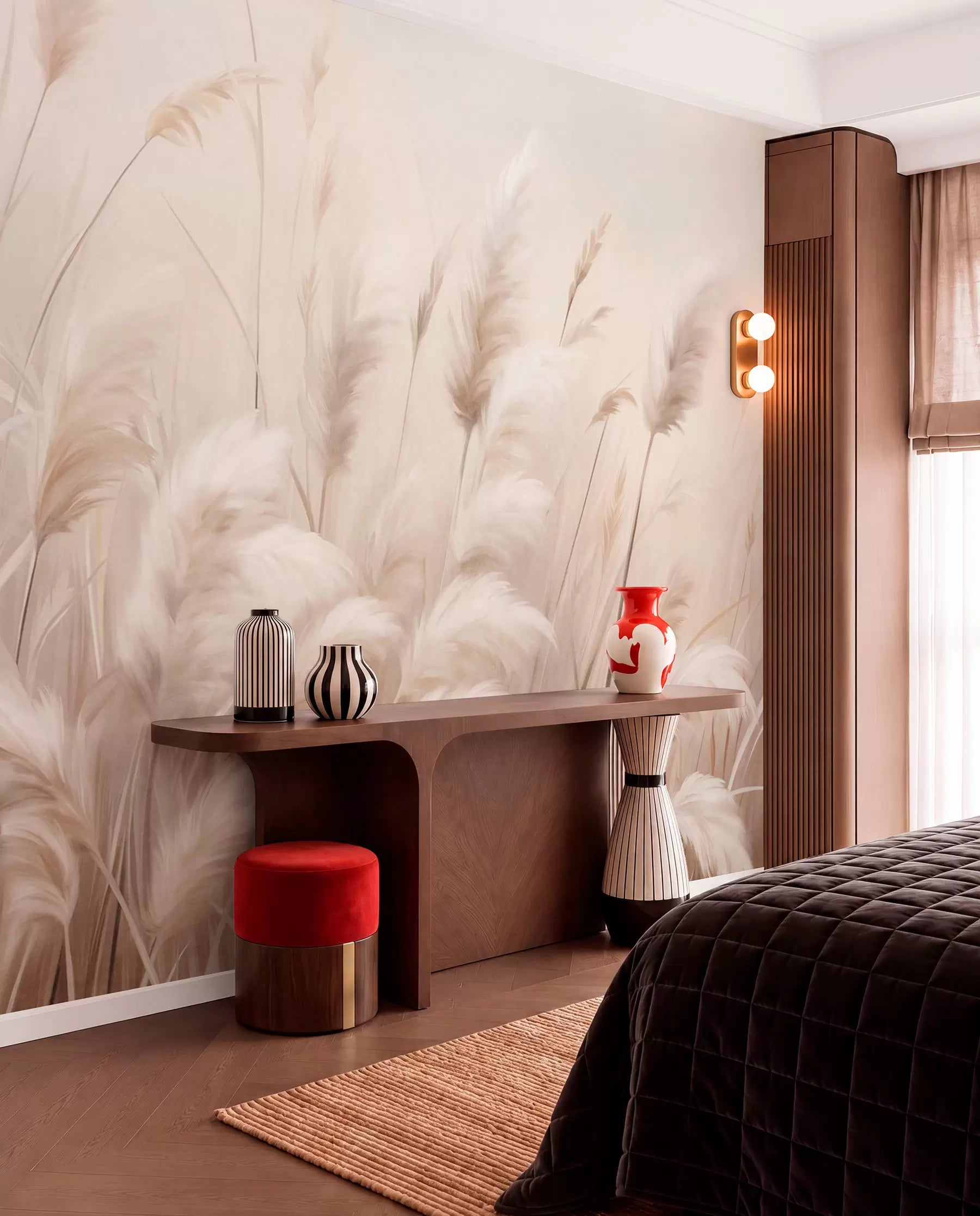 Fluffy pampas grass wall mural in warm neutral tones behind a wooden console and red stool