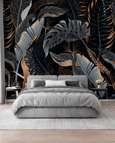 Teal and gold tropical foliage on a black background wall mural behind a grey bed