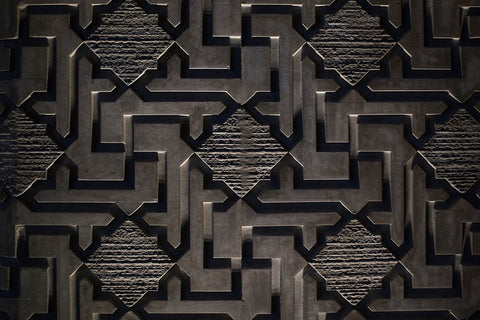 Monolith cube with labyrinth pattern floating above concrete floor